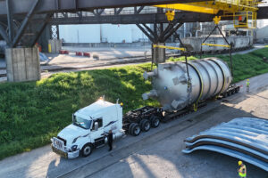 A truck driver prepares for departure from Ports of Indiana-Mount Vernon while Indiana River & Rail Terminals crews complete transload of this 51-ton, 44-by-18-foot pharmaceutical production tank from a barge on the Ohio River.